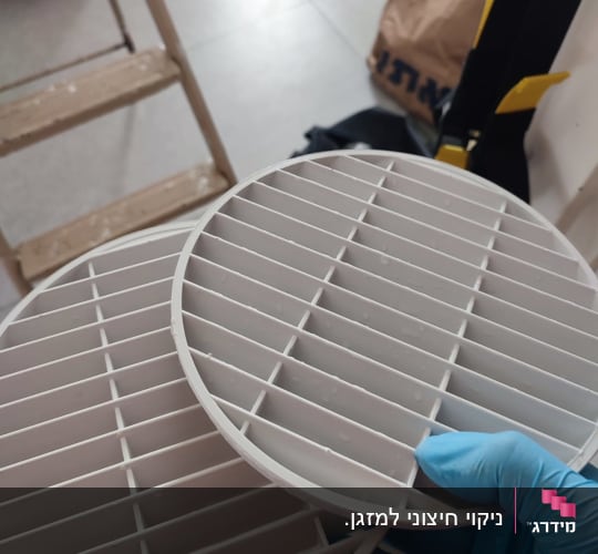 שתי רשתות עגולות לאוורור מוחזקות ביד עם כפפה כחולה